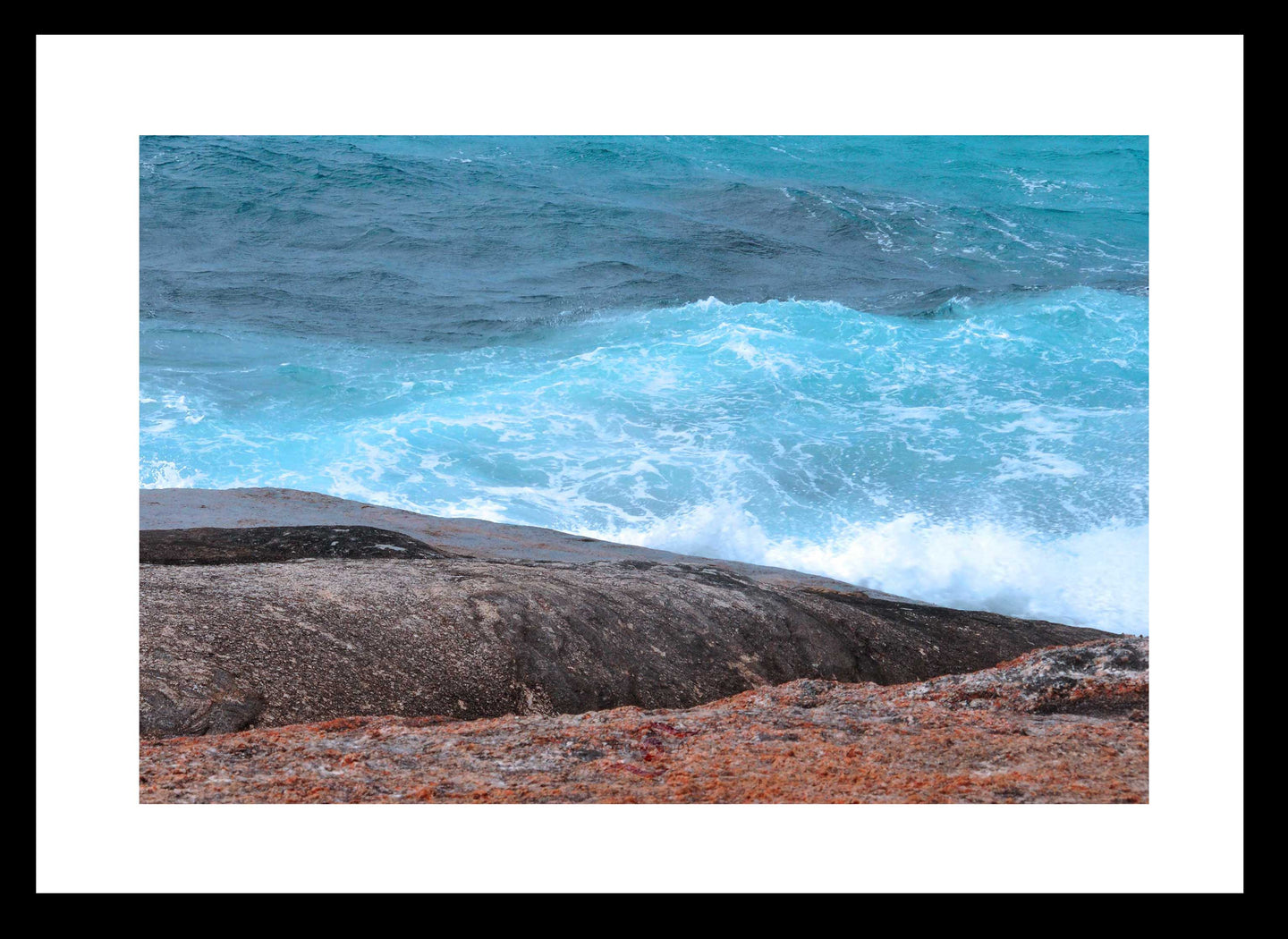 Ocean Photography Wall Art Print of the hypnotic blues of the ocean contrasting with wave drenched rocks, taken at Madfish Bay, Denmark, Western Australia. Fine Art Print with Black Frame. 