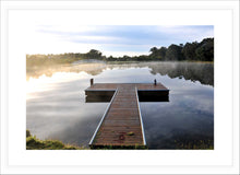 Load image into Gallery viewer, Jetty Photography Wall Art Print of a misty morning sun rise with beautiful reflections on the tranquil lake viewed from the T shaped, peaceful jetty. Fine Art Print with White Frame.
